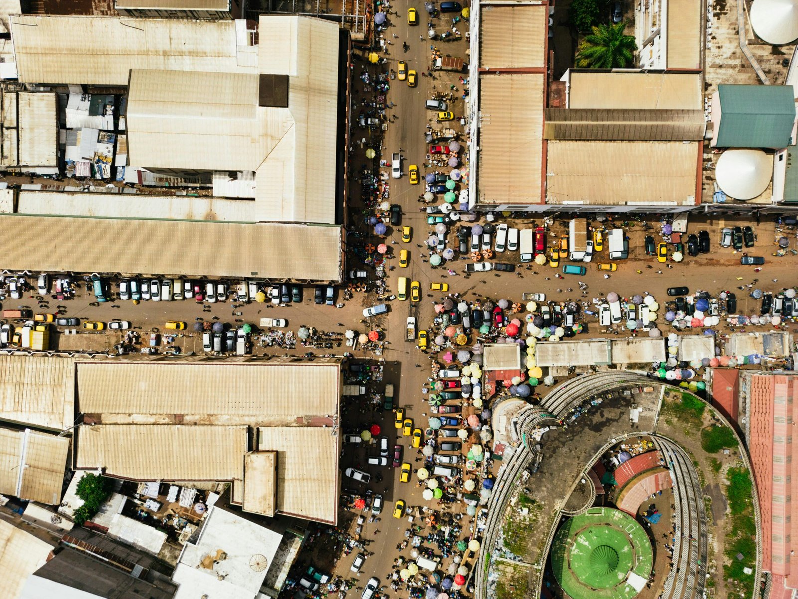A bustling market street in Yaoundé, Cameroon, captured from above showing vibrant city life and architecture.